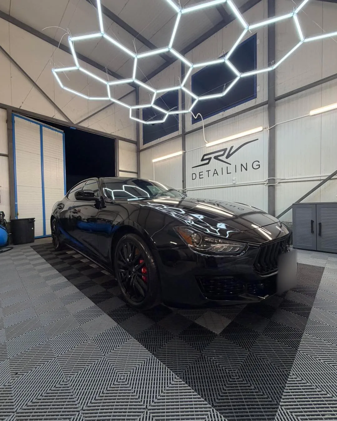 Черно Maserati, заснето отпред под хексагоналното осветление в студиото